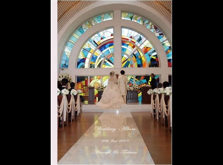 表紙は虹のように大きなステンドグラスが美しいチャペルでの後ろ姿。1頁目：結婚式アルバム