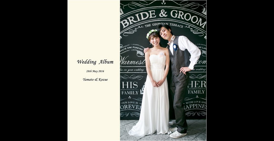 黒板風フォトブースでポーズをとる新郎新婦がオシャレに決まっていますね。1頁目：結婚式アルバム