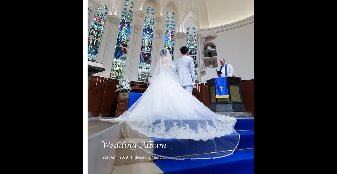 ドレスのトレーンが美しく広がるこちらの表紙、ロイヤルブルーのバージンロードに映える純白のウエディングドレスにうっとりとしてしまいます。1頁目：結婚式アルバム