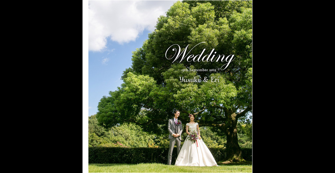 見上げるほどの大きな木の下で微笑むお二人が爽やかな表紙のこちらは大阪の迎賓館。1頁目：結婚式アルバム
