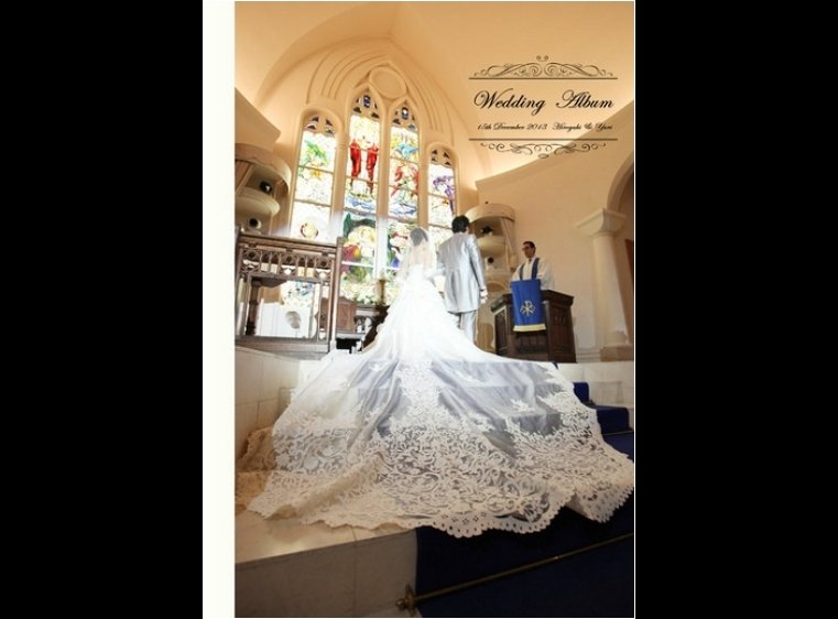 ヨーロッパの大聖堂を思わせるチャペル、聖なる光をそそぐステンドグラス、ブルーのバージンロードに映える白いドレスのロングトレーン。1頁目：結婚式アルバム